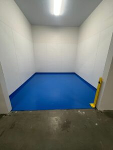 Light blue solid epoxy floor coating installed in a Bakersfield warehouse bay