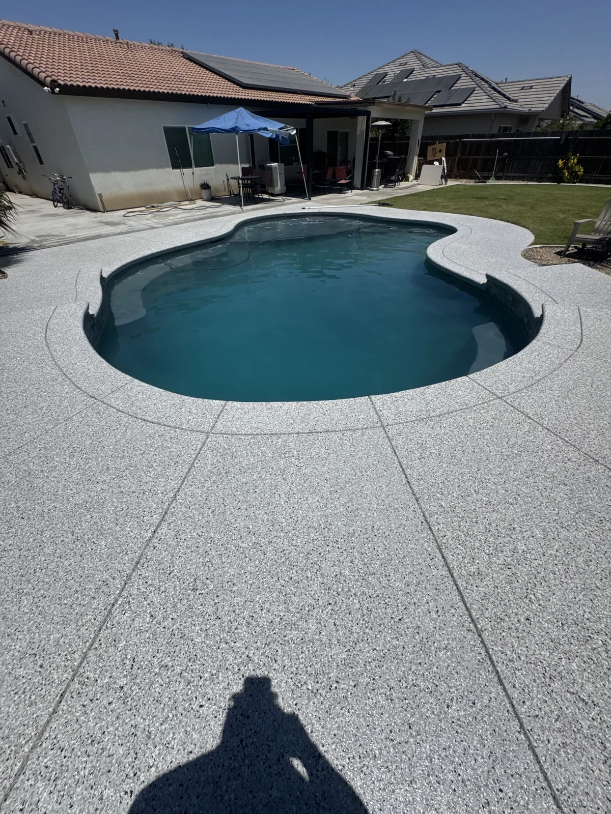 California Grey flake pool deck coating around a backyard pool in Bakersfield, CA