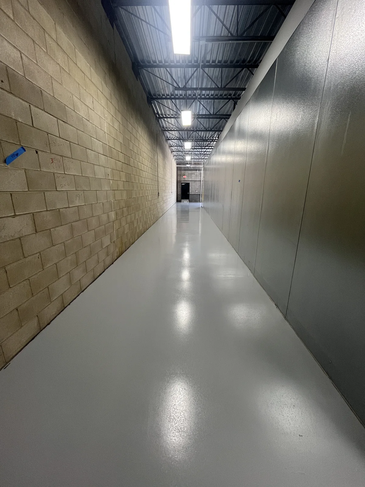 Finished solid color floor coating in a commercial freezer building corridor in Bakersfield, CA