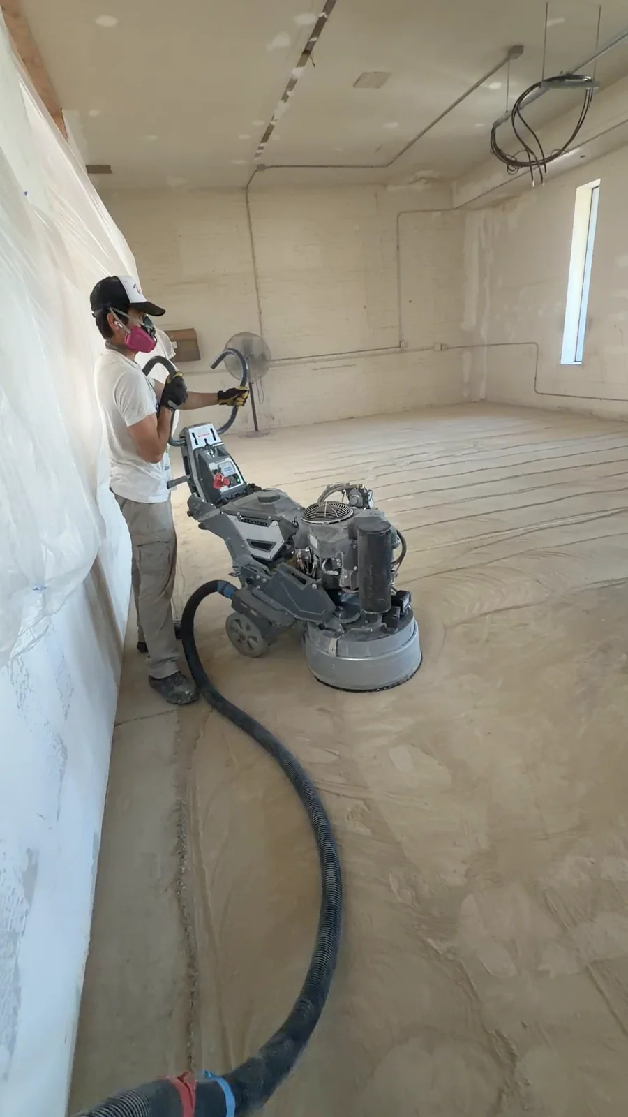 Husky Coatings crew diamond grinding a commercial concrete slab with dust extraction in Bakersfield, CA