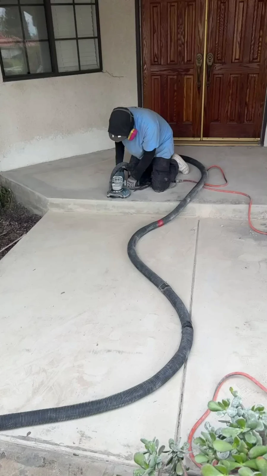 Husky Coatings crew edge grinding a front entry slab with vacuum dust control in Bakersfield, CA