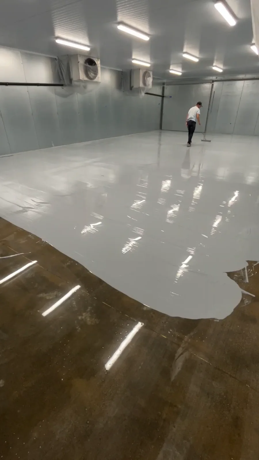 Husky Coatings crew rolling epoxy basecoat in a commercial freezer room in Bakersfield, CA