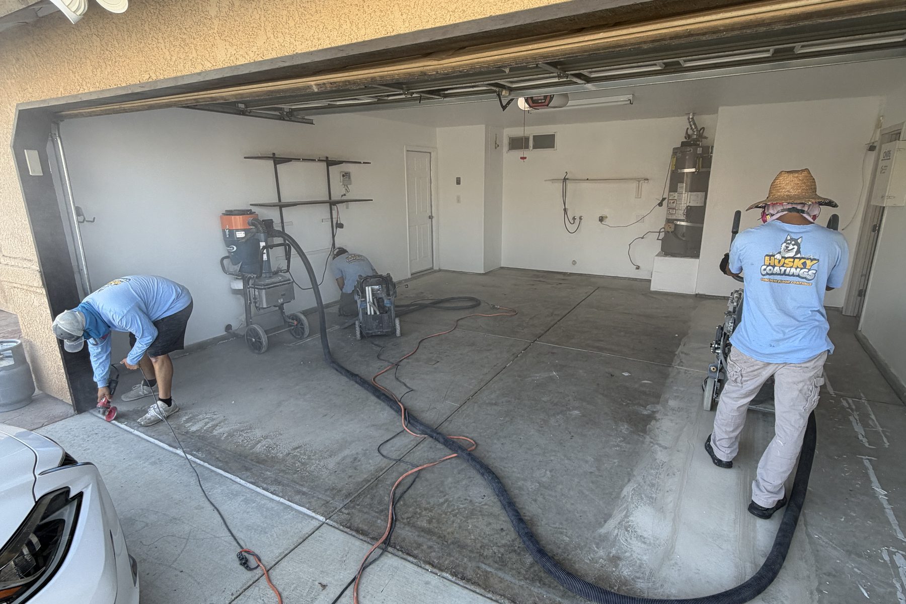 Husky Coatings crew grinding a garage floor in Shafter CA before epoxy coating