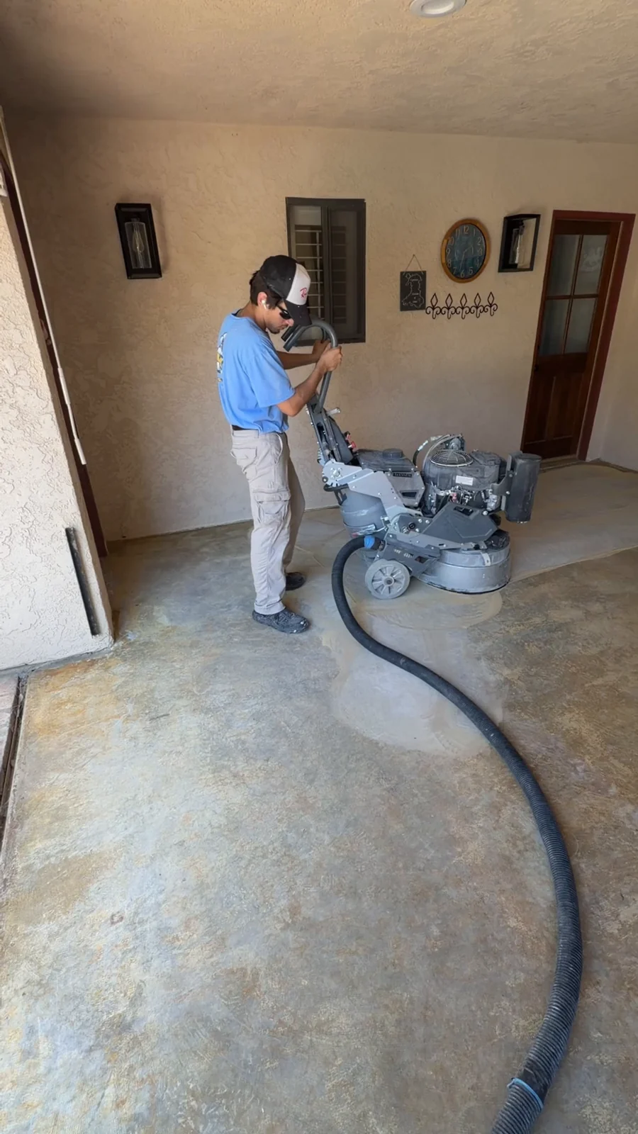 Husky Coatings crew grinding old adhesive off a covered patio slab in Bakersfield, CA