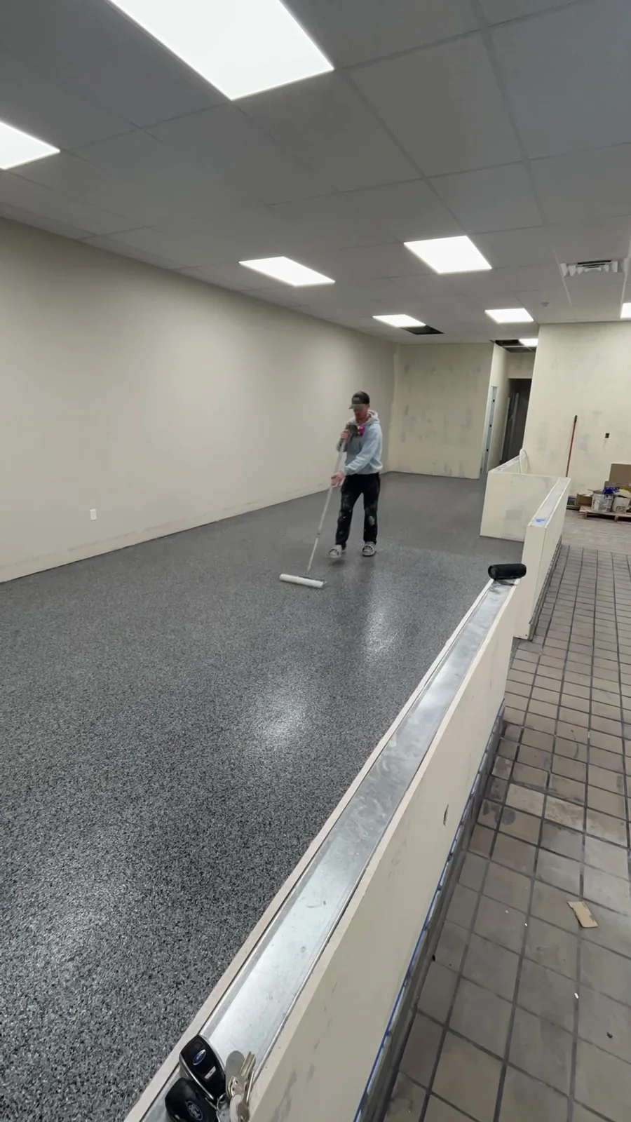 Husky Coatings crew rolling sealer over the graphite flake floor at a juice bar in Bakersfield, CA